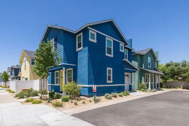 A blue house with green trim and yellow shutters.