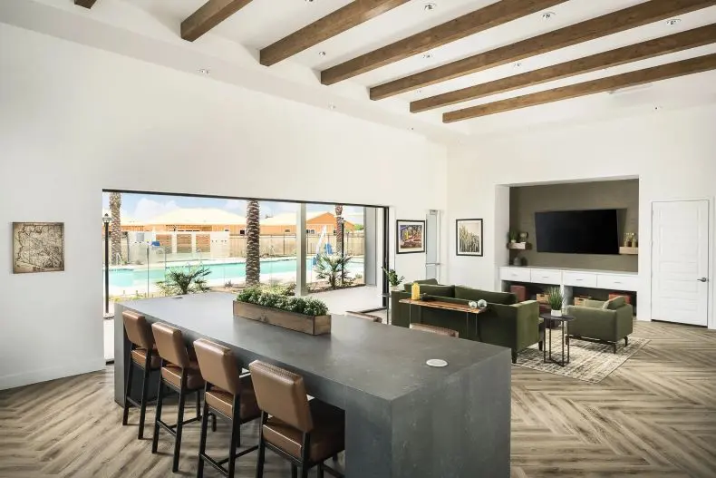 A large room with a bar and chairs in it