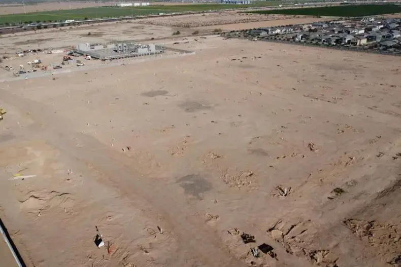 Desert landscape with distant buildings and roads.